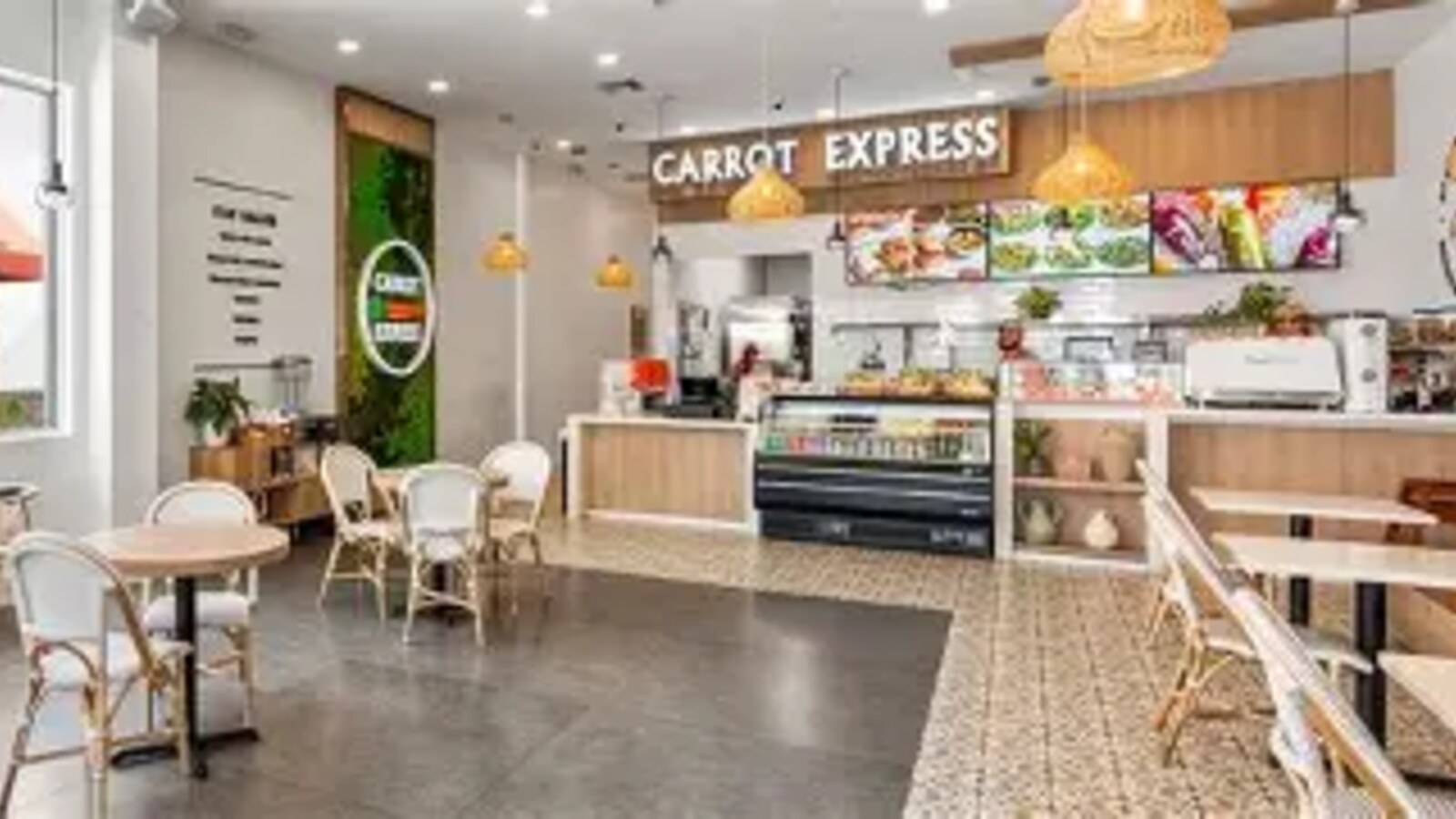 Carrot Express bright interior with branded signage, greenery wall, and café seating at The Shops at Pembroke Gardens
