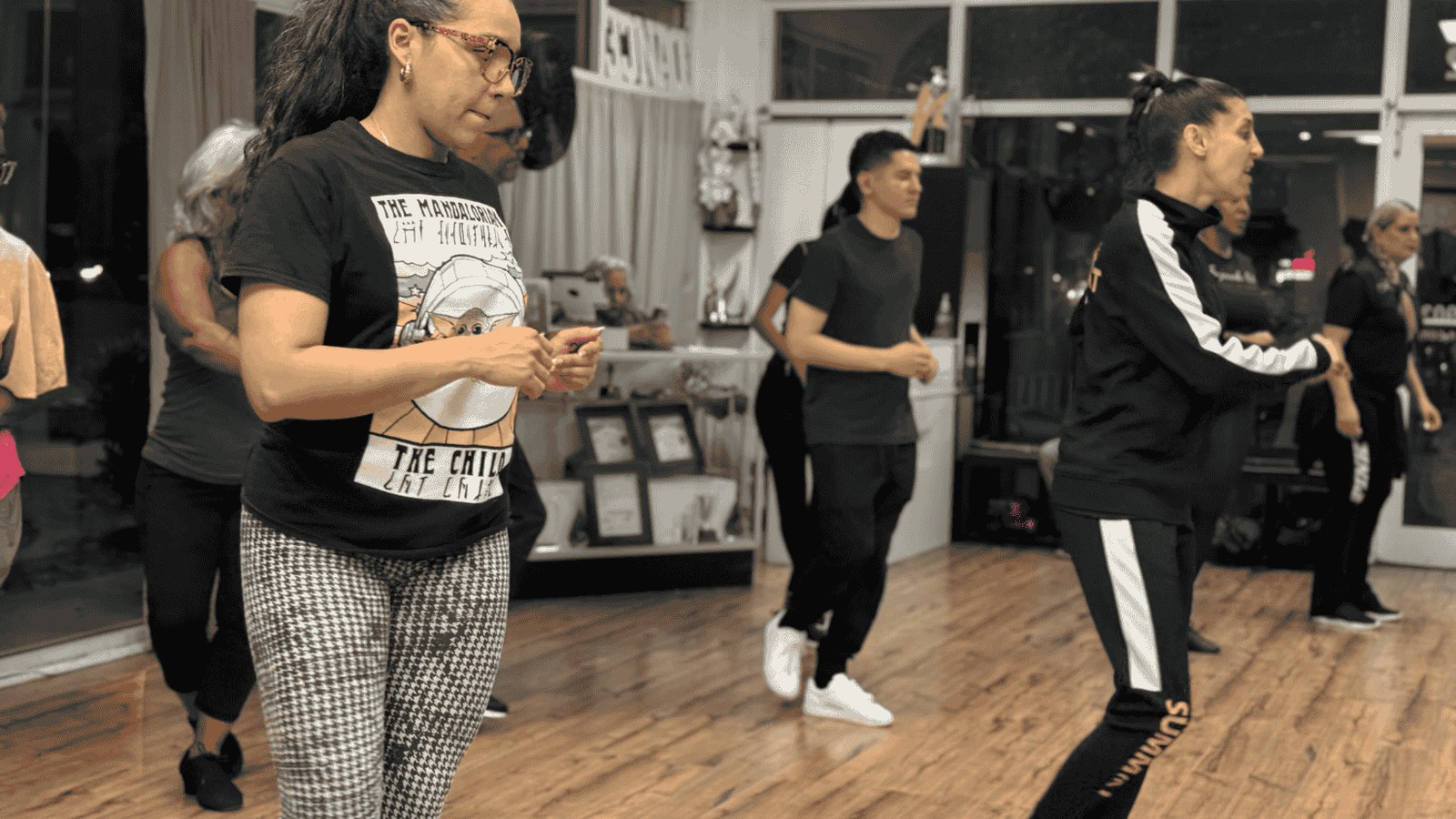 Adult students practicing social dance steps during a group class at Fajardo Elite Dance Academy in Davie