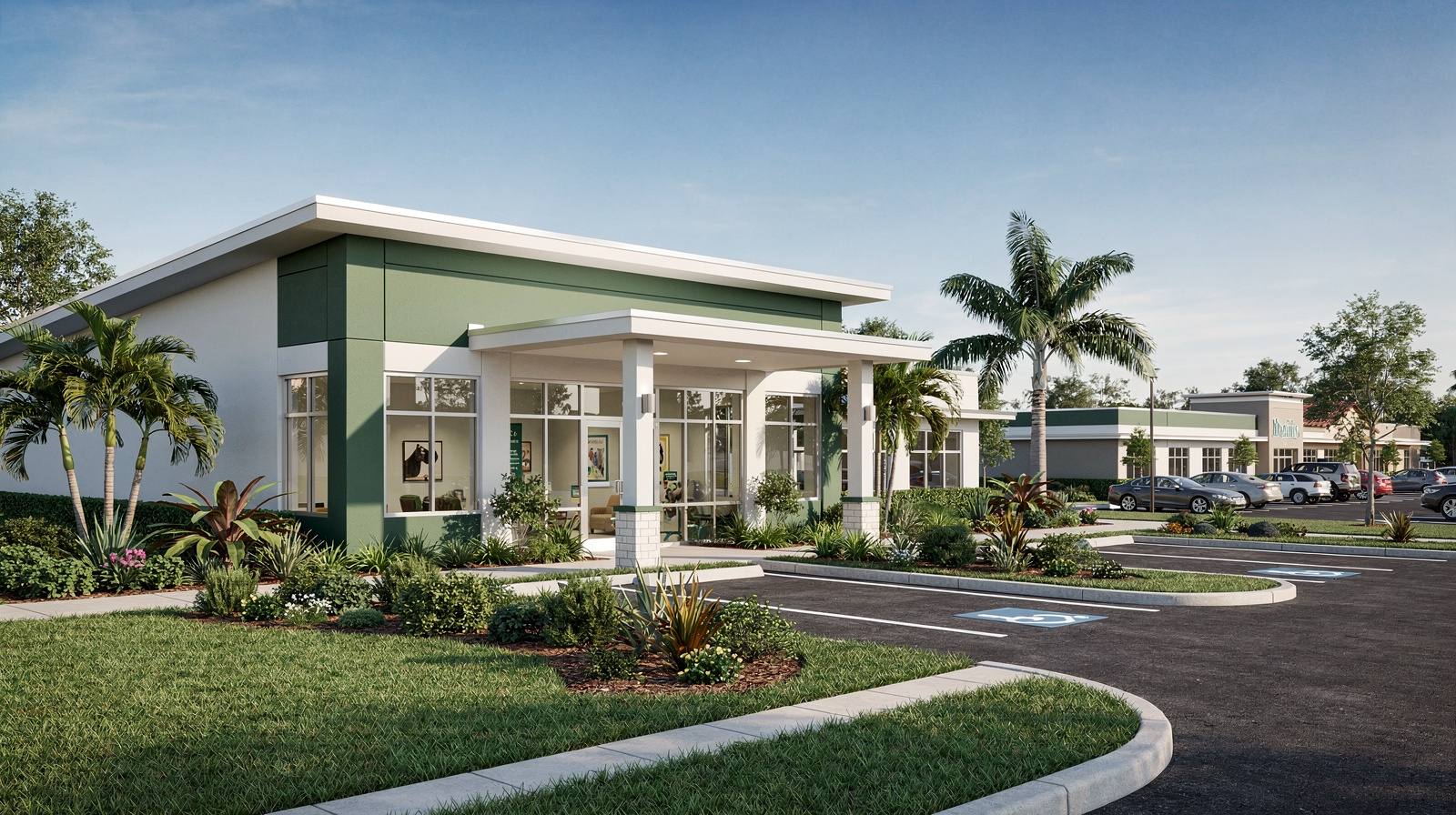 Representative exterior of a trusted local animal hospital with green and white accents and lush tropical grounds