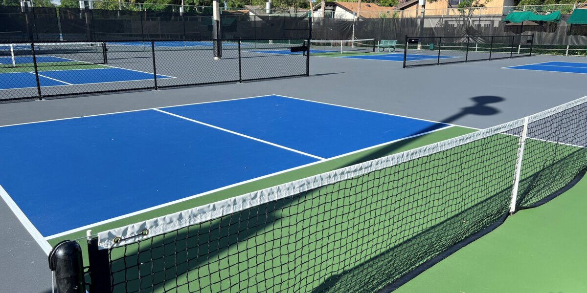 Outdoor pickleball courts at Paul J. Maxwell Park in Pembroke Pines with players on the courts under bright blue Florida sky
