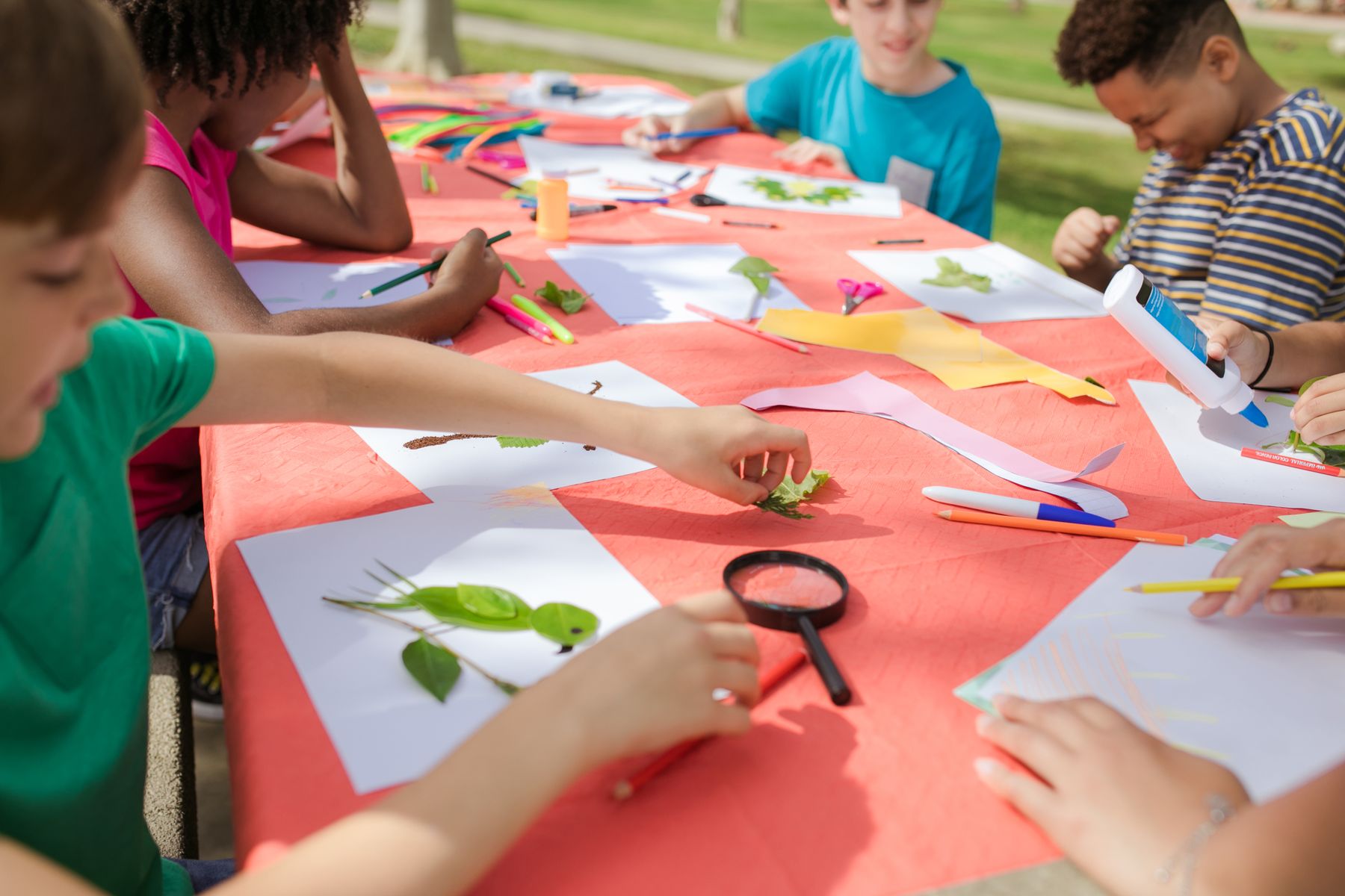 Representative Pexels stock photo, not a local camp: children making crafts outdoors.